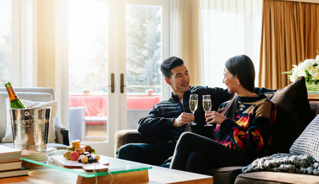 Couple enjoying a sparkling beverage in the Stanley Thompson Cabin at Fairmont Jasper Park Lodge