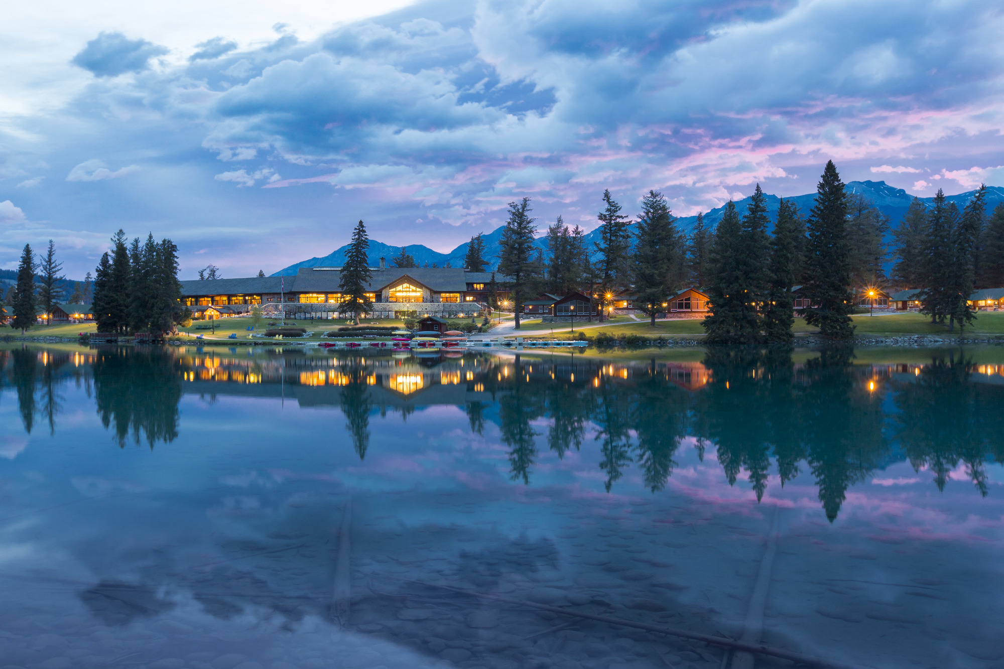 Jasper Park Lodge is seen from across the lake with a colourful sky