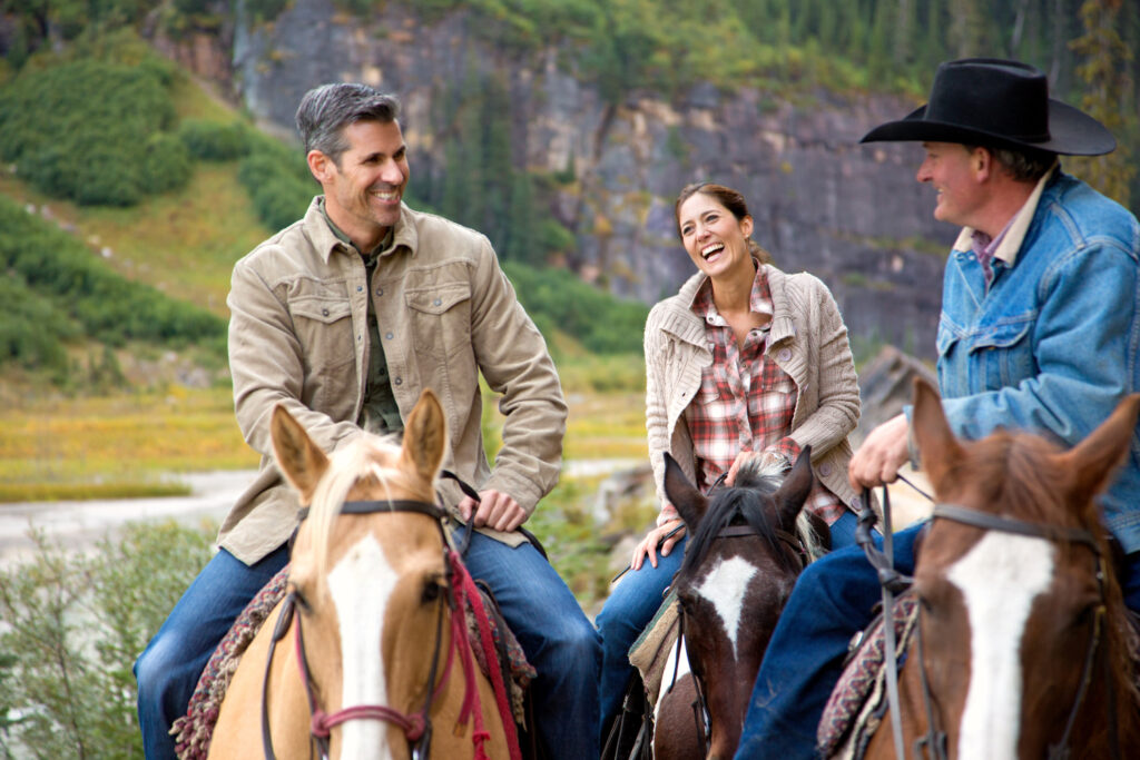 Lake Louise Activities - Couples Travel - A couple on a Brewster Stables horseback riding tour at the Fairmont Chateau Lake Louise with Brewster Stables