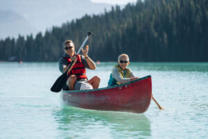 Lake Louise in Spring/Summer- Resort Activities- A father and son canoeing on Lake Louise- Family Travel