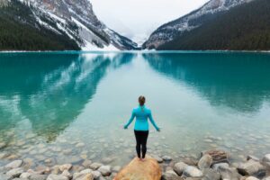 Lake Louise in Spring- Wellness Retreat -Woman on shores of Lake Louise