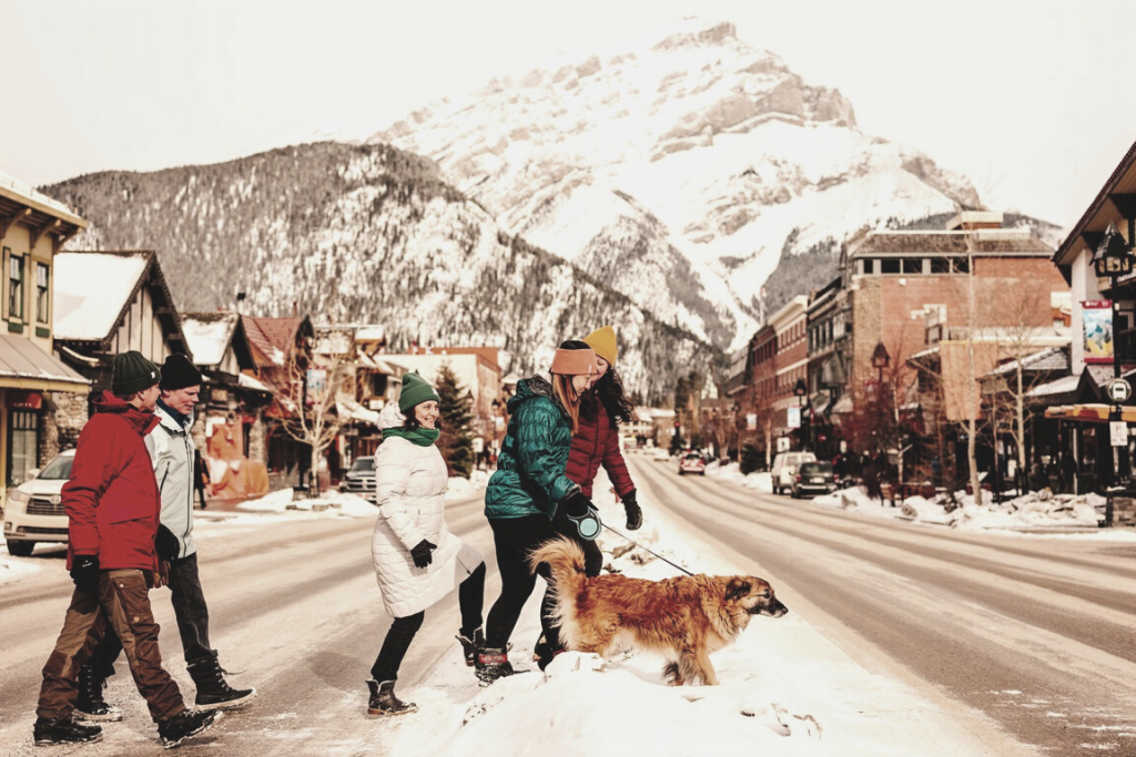 Travelling with pets in Banff, a dog-friendly vacation destination - A family walking their dog in Banff, Destination Canada