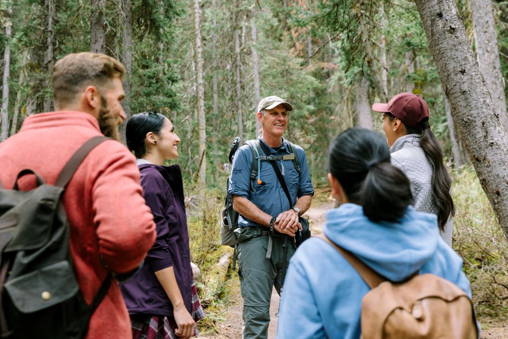 Mountain Adventure Guide speaking to a group in the forests of Lake Louise