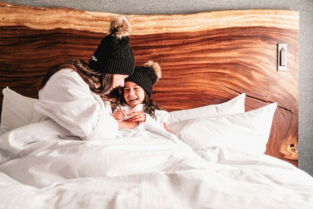 Mother and Daughter cuddled up in bed at Fairmont Chateau Whistler