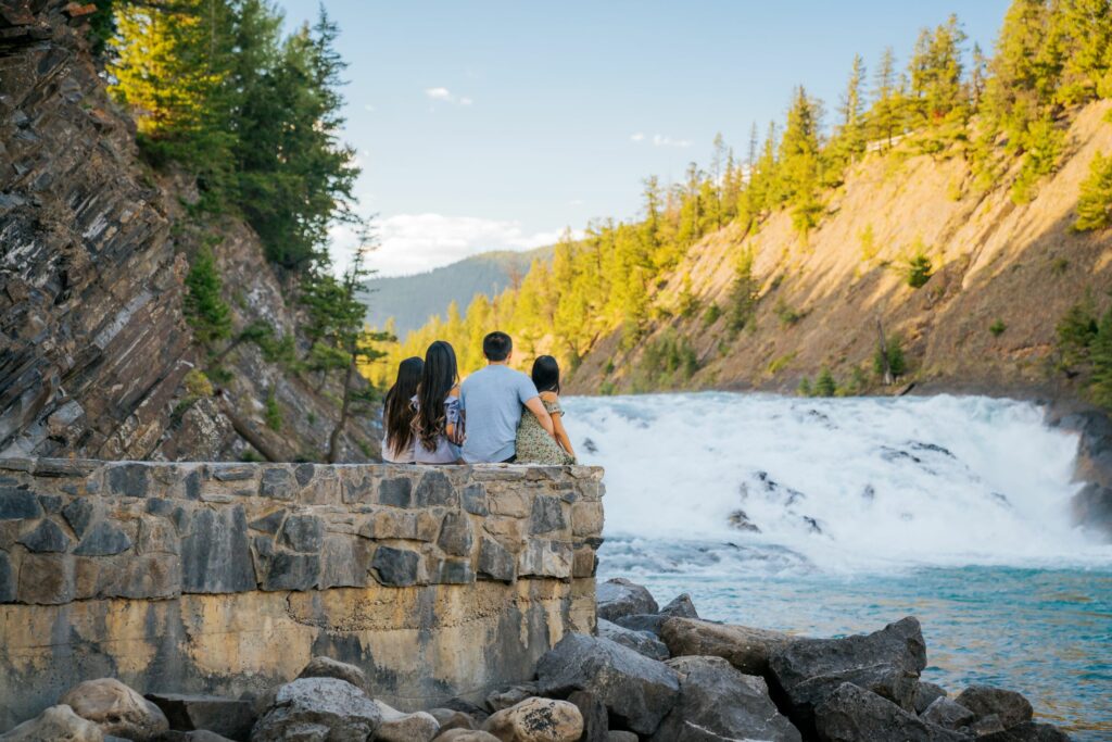 Family looking at Bow Falls in Summer, Banff National Park. Photo by Banff Lake Louise Tourism / ROAM Creative.