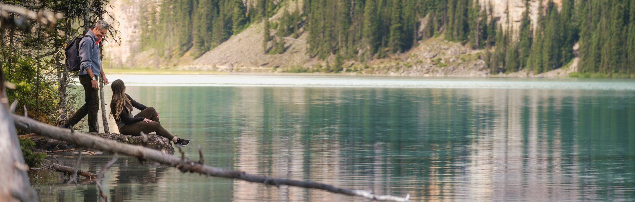 A Couple on Lake Louise shoreline in Spring/Summer