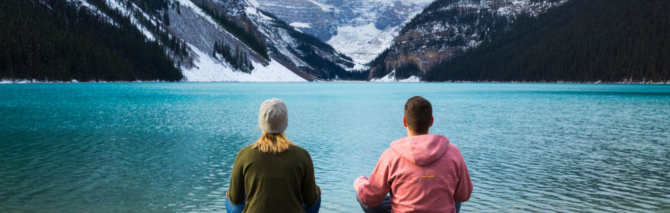Lake Louise in Spring- Couples Travel - A couple on the shores of Lake Louise